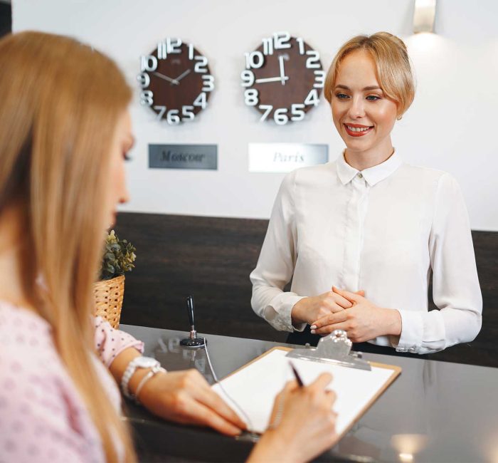 blonde-woman-hotel-guest-checking-in-at-front-desk-2021-09-03-05-46-20-utc.jpg